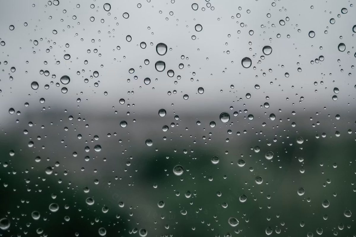 Gotas de lluvia sobre un vidrio, de tamaño y posición genuinamente aleatoria en dos ejes, con el paisaje desenfocado detrás: la misma anatomía de un diagrama de dispersión, donde cada punto es un caso individual ubicado por dos coordenadas
