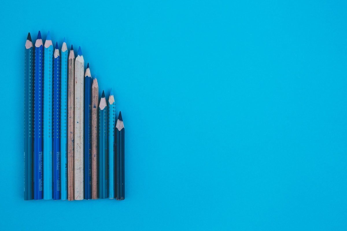 Lápices de colores ordenados de mayor a menor altura formando una curva descendente nítida: el ordenamiento es la clave perceptiva de un pareto chart, donde el ranking importa tanto como el valor