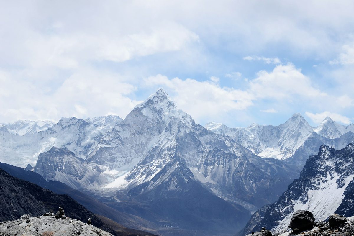 Cordillera con capas de picos a distinta profundidad superpuestos por perspectiva atmosférica: la superposición parcial de siluetas que imita un ridge plot con curvas de densidad apiladas